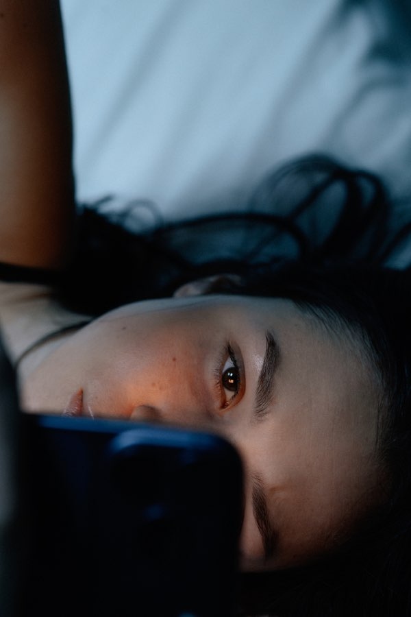 Frau im Bett am Handy